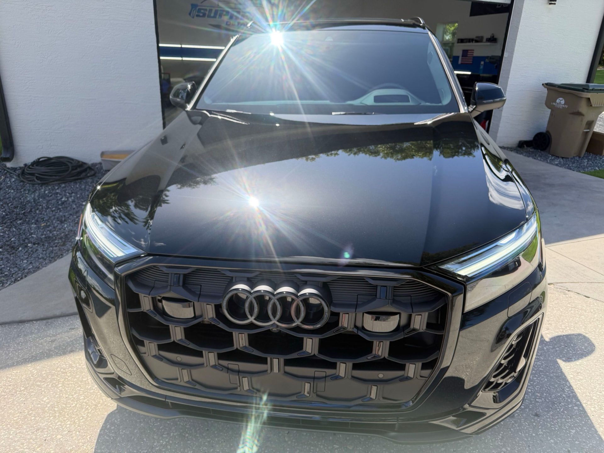Close-up of a black Audi hood showing deep gloss and reflection after paint correction